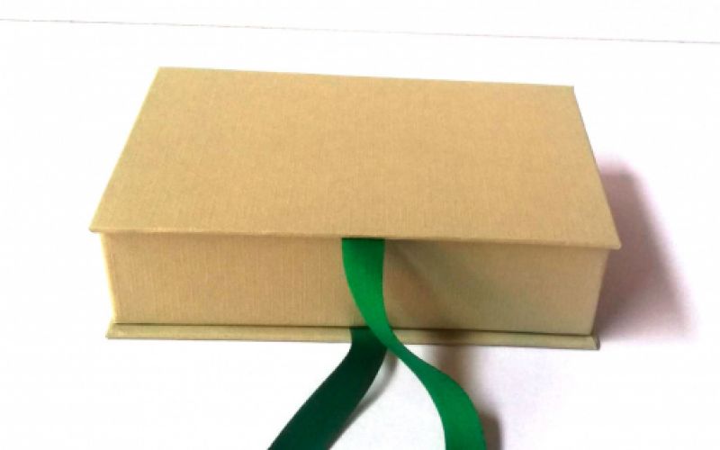 caixa marró clar horitzontal amb tapa i tancament amb cinta de color verd