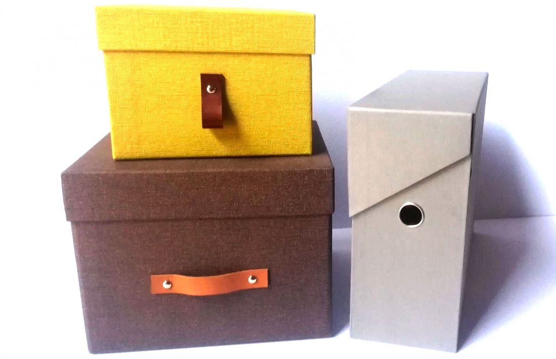 dos cajas de cartón marrón y amarilla con tapa y archivador gris